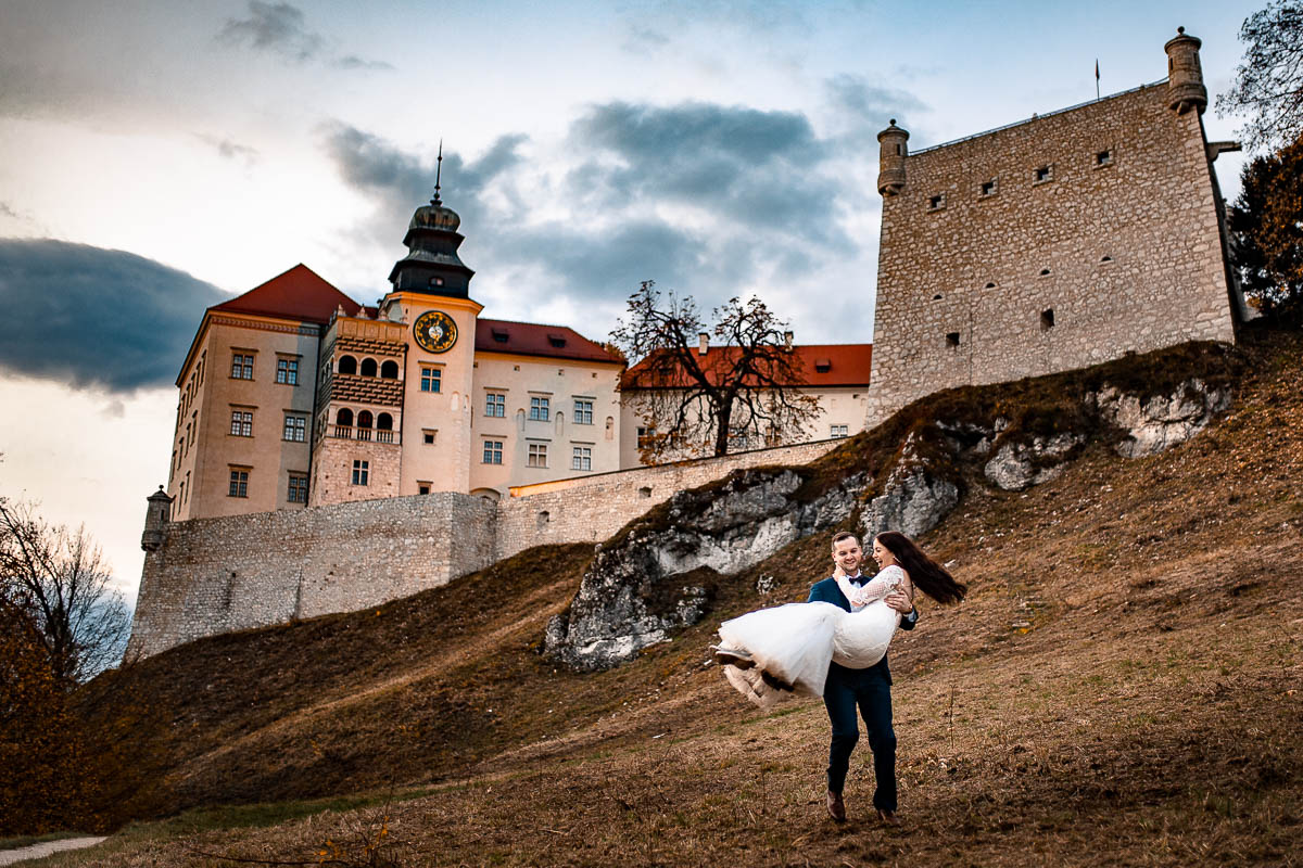 On i ona zakręceni radośnie patrzą na zamek w Ojcowie.na sesja ślubna Kraków.